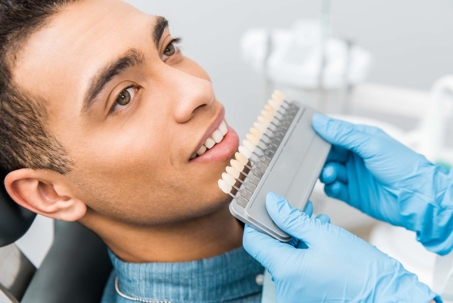 patient looking at a display of veneers