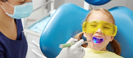 dental hygienist conducting a check up on a child
