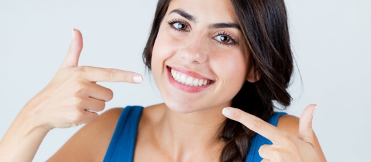 woman pointing at her smile